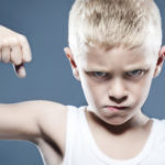 Young child showing his muscles